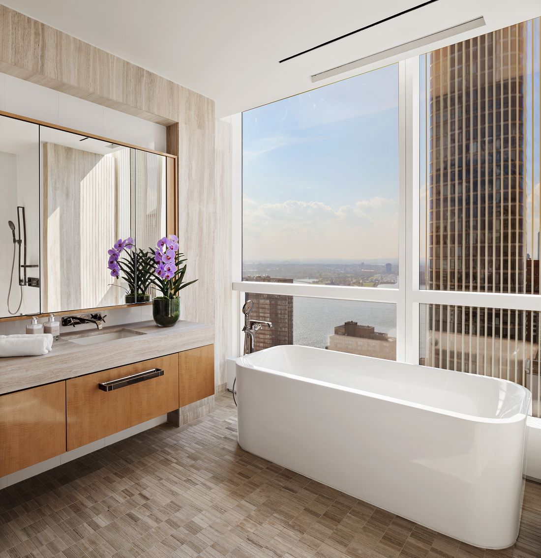 The primary bath with a freestanding tub set against a window with harbor views