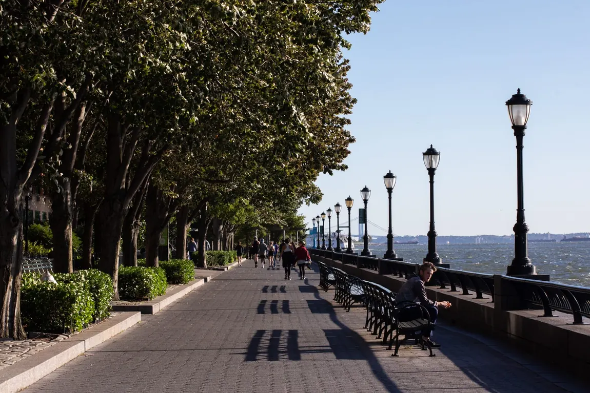 The tree-lined Hudson River Greenway esplanade with walkers and joggers