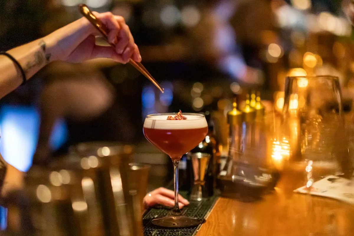 A craft cocktail being finished at the bar