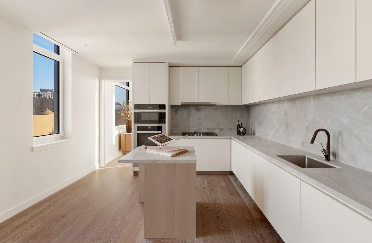 The kitchen with Blue de Savoie marble, Poliform oak cabinetry, and integrated appliances